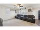 Spacious living room with neutral walls, dark leather couches and large windows at 2669 Champagne Gold Ave, North Las Vegas, NV 89086