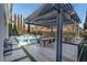 Outdoor kitchen, pergola, and refreshing pool with a dining area at 304 Elder View Dr, Las Vegas, NV 89138