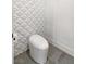 Modern powder room with unique geometric wall tiles and a sleek toilet at 304 Elder View Dr, Las Vegas, NV 89138