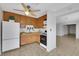 Kitchen with wood cabinets, white appliances, and view into living area at 4642 Via San Rafael, Las Vegas, NV 89103