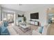 Virtually staged living room featuring light beige sofas and a large TV at 4642 Via San Rafael, Las Vegas, NV 89103