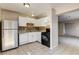 Kitchen featuring white cabinets, tile backsplash, and black appliances at 4721 Via Renaldo, Las Vegas, NV 89103