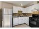 Bright kitchen featuring white cabinets, tile backsplash, and stainless steel refrigerator at 4721 Via Renaldo, Las Vegas, NV 89103