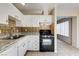 Kitchen featuring white cabinets, decorative backsplash, and black gas range at 4721 Via Renaldo, Las Vegas, NV 89103