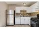 Bright kitchen with stainless steel refrigerator, white cabinets, and decorative backsplash at 4721 Via Renaldo, Las Vegas, NV 89103