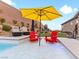 Pool with red chairs and yellow umbrella at 49 Strada Caruso, Henderson, NV 89011