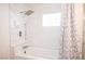 Bathtub with a glass tile window and a shower head with white marble tile at 5515 Coley Ave, Las Vegas, NV 89146