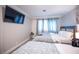 Bright bedroom featuring a large TV, wood floors, and two beds at 5515 Coley Ave, Las Vegas, NV 89146