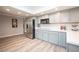 Modern kitchen with a large stainless steel refrigerator, gray cabinets, and wood look floors at 5515 Coley Ave, Las Vegas, NV 89146