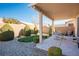 Covered patio with seating area, grassy lawn, and desert landscaping at 7436 Wagonwheel Ranch Way, Las Vegas, NV 89113