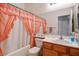 Bathroom with shower/tub combo, wood vanity, and peach curtains at 7436 Wagonwheel Ranch Way, Las Vegas, NV 89113