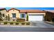 Tan house with tile roof, landscaping, and a two-car garage at 7436 Wagonwheel Ranch Way, Las Vegas, NV 89113