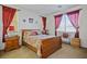 Main bedroom with wood sleigh bed, red curtains, and side tables at 7436 Wagonwheel Ranch Way, Las Vegas, NV 89113