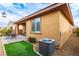 Backyard featuring an air conditioning unit, artificial turf, rock surround, and patio area at 7611 Redcloud Peak St, Las Vegas, NV 89166