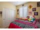 Bedroom featuring playful decor, comfortable bed, and ample natural light from shuttered window at 7611 Redcloud Peak St, Las Vegas, NV 89166