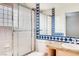 Clean bathroom with blue and white tile, a shower, and granite vanity at 8600 Kiel Ridge Cir, Las Vegas, NV 89117