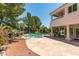 Backyard view of the home with a stone patio and private pool at 2604 Sun Reef Rd, Las Vegas, NV 89128