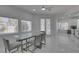 Bright dining room with glass table, gray chairs, and views of kitchen and backyard at , Las Vegas, NV 89128