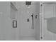 Modern shower with white tiled walls and showerhead with gray fixtures at , Las Vegas, NV 89128