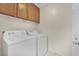 Functional laundry room with washer, dryer, and upper cabinets, offering convenient storage at 10424 Wyatt Earp Ct, Las Vegas, NV 89129