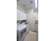 Bright laundry room, washer, dryer, cabinets, and tile floors at 10470 W Ann Rd Rd, Las Vegas, NV 89149