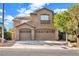 Two-story house with tan siding, two-car garage, and landscaping at 10636 Amblewood Way, Las Vegas, NV 89144