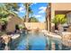 Inviting pool with rock waterfall feature and ample lounge space at 10636 Amblewood Way, Las Vegas, NV 89144