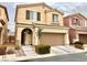 Two-story house with tan exterior, two-car garage, and landscaping at 10636 Tulip Valley Rd, Las Vegas, NV 89179