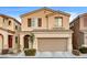 Two-story house with tan exterior, brown garage door, and landscaping at 10636 Tulip Valley Rd, Las Vegas, NV 89179