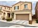 Two-story house with tan exterior, two-car garage, and landscaping at 10636 Tulip Valley Rd, Las Vegas, NV 89179