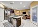 Open concept kitchen with island, dark cabinets, and stainless steel appliances at 10636 Tulip Valley Rd, Las Vegas, NV 89179