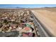 Community aerial view showcasing terracotta tile roofs of a home near a desert highway at 1138 Gainesborough Ct, Henderson, NV 89015