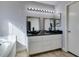 Bathroom featuring double sinks, a large mirror, and a soaking tub at 1138 Gainesborough Ct, Henderson, NV 89015