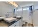 Bathroom featuring double sinks, a vanity with storage, and a shower with glass doors and blue curtain accents at 1138 Gainesborough Ct, Henderson, NV 89015