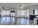 Spacious living room with wood-look floors, ceiling fans, fireplace, and lots of natural light from large windows at 1138 Gainesborough Ct, Henderson, NV 89015