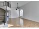 Spacious living room featuring a large window, wood flooring, and staircase at 1138 Gainesborough Ct, Henderson, NV 89015