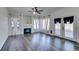 Living room featuring wood-look floors, fireplace, ceiling fan, and glass doors and windows with curtains at 1138 Gainesborough Ct, Henderson, NV 89015