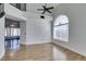 Bright living room with wood floors, ceiling fan, and large arched window allowing ample natural light at 1138 Gainesborough Ct, Henderson, NV 89015