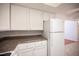 Kitchen with white cabinets, granite countertops, and modern white appliances at 1701 E Katie Ave # 65, Las Vegas, NV 89119