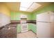 Well-lit kitchen featuring light green cabinetry and a full suite of appliances at 1701 E Katie Ave # 65, Las Vegas, NV 89119