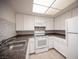 Bright kitchen with white appliances, sleek countertop, and a clear view of the eat-in nook at 1701 E Katie Ave # 65, Las Vegas, NV 89119