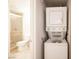 Bathroom and laundry room with a stacked washer and dryer and adjacent toilet and shower at 1701 E Katie Ave # 65, Las Vegas, NV 89119