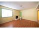 Bright living room featuring wood floors, large window, fireplace, and freshly painted walls at 1701 E Katie Ave # 65, Las Vegas, NV 89119