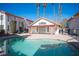 Inviting community pool with clear blue water, surrounded by well-maintained buildings and tall palm trees under a sunny sky at 1701 E Katie Ave # 65, Las Vegas, NV 89119