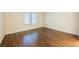 Well-lit bedroom with wood-look flooring and neutral walls at 1859 Cypress Greens Ave, Henderson, NV 89012