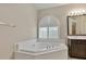 Bright bathroom features a soaking tub with a window view and a modern vanity at 2026 Dakota Lodge Ave, Las Vegas, NV 89123