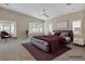 A spacious and well-lit main bedroom featuring neutral carpet, ceiling fan, and large windows at 2026 Dakota Lodge Ave, Las Vegas, NV 89123