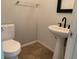 Small bathroom with pedestal sink, toilet, and tiled floor at 2821 White Peaks Ave, North Las Vegas, NV 89081