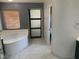 Bathroom with soaking tub, a large window, and a stylish sliding door at 2821 White Peaks Ave, North Las Vegas, NV 89081