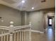 Hallway with tile floors and white railing, illuminated by recessed lighting at 2821 White Peaks Ave, North Las Vegas, NV 89081